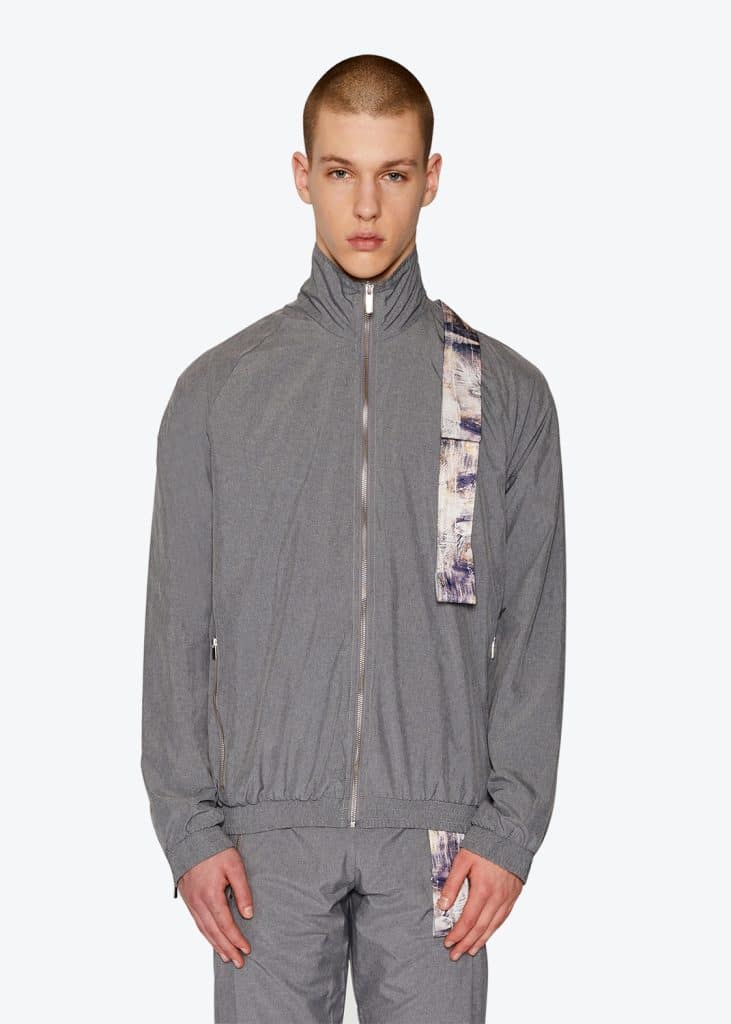 A man wearing a grey track jacket and pants on model.
