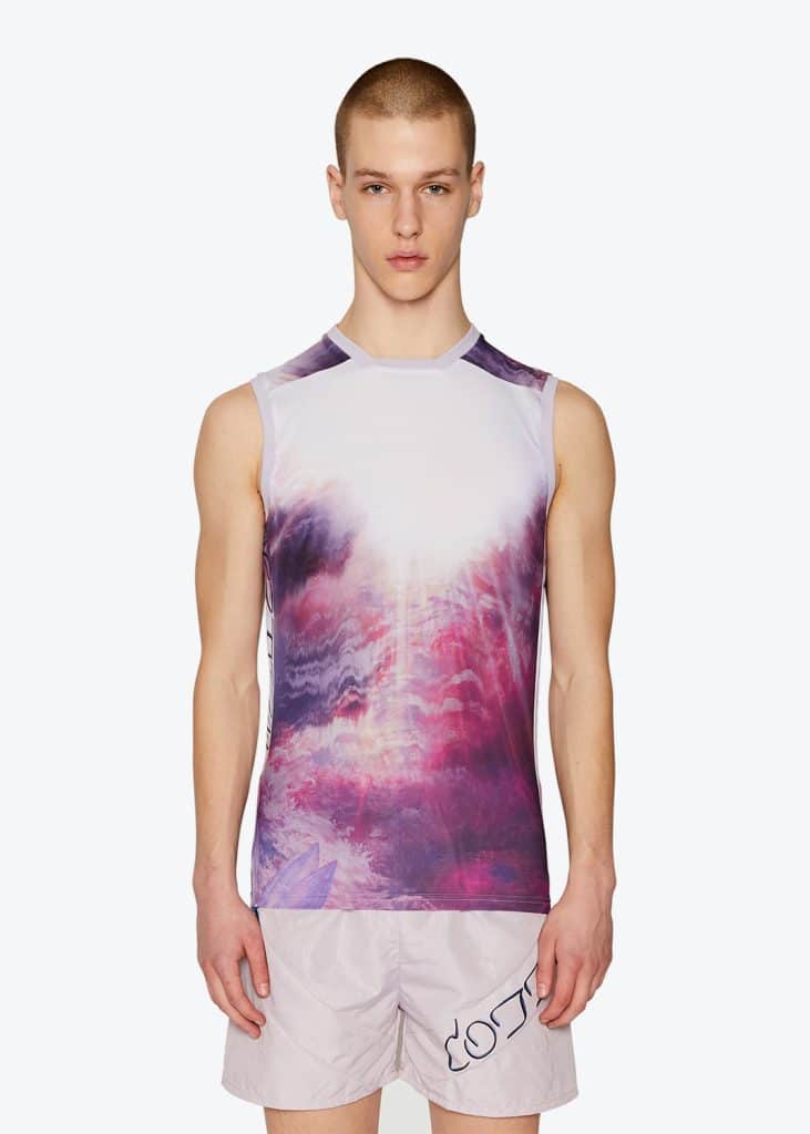 A man wearing a purple tank top and shorts, online.